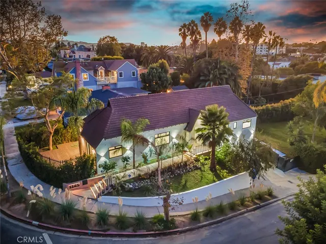 a view of a house with a yard and potted plants