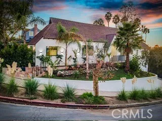 a view of a house with a yard and potted plants