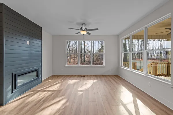 a view of an empty room with a window and wooden floor
