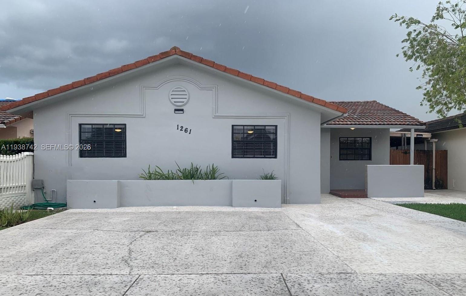 1261 Southwest 138th Court Miami, FL 33184 - Photo 1 of 11 a front view of a house with a yard and garage