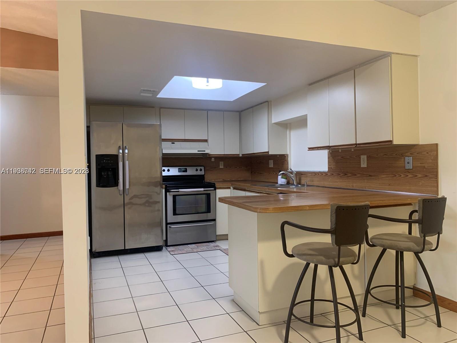 1261 Southwest 138th Court Miami, FL 33184 - Photo 6 of 11 a kitchen with granite countertop a refrigerator and a stove top oven