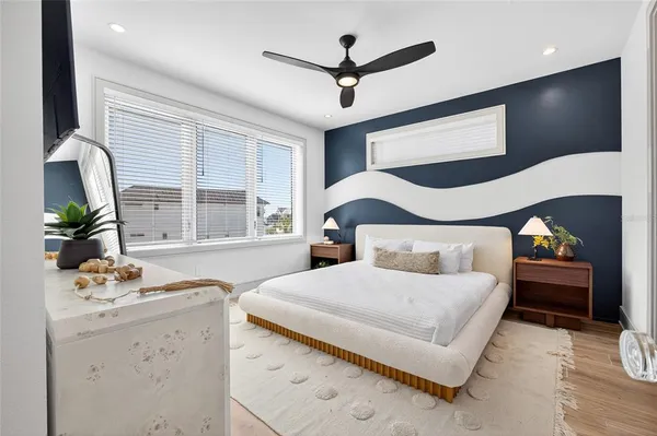 a bedroom with a bed and a large window with the outer view
