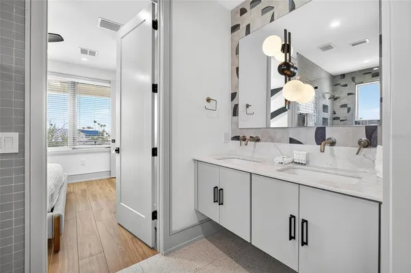 a bathroom with a double vanity sink mirror and shower
