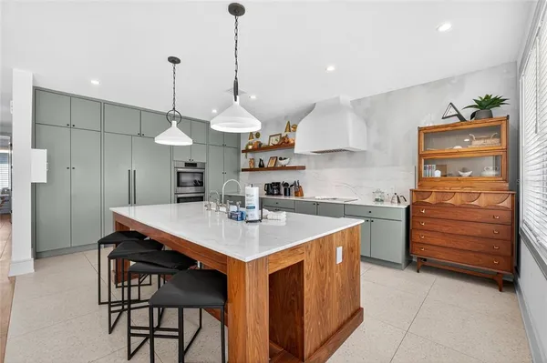 a kitchen with a sink a stove cabinets and wooden floor
