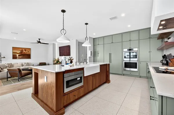 a large kitchen with kitchen island a large counter space a sink appliances and cabinets