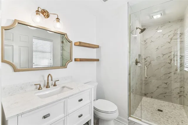 a bathroom with a sink a toilet and shower