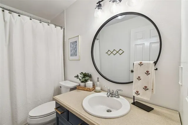 a bathroom with a sink toilet and a mirror