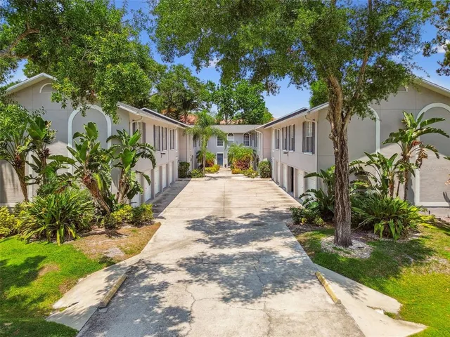 a view of house with backyard and trees