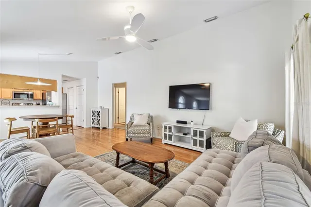 a living room with furniture kitchen view and a flat screen tv