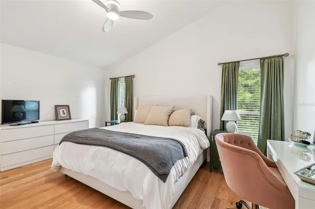 a bedroom with a bed a flat screen tv and a large window
