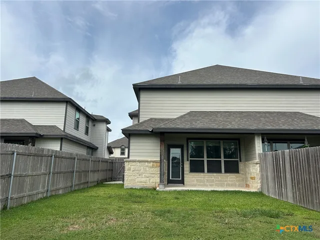 a house that has a big yard with wooden fence