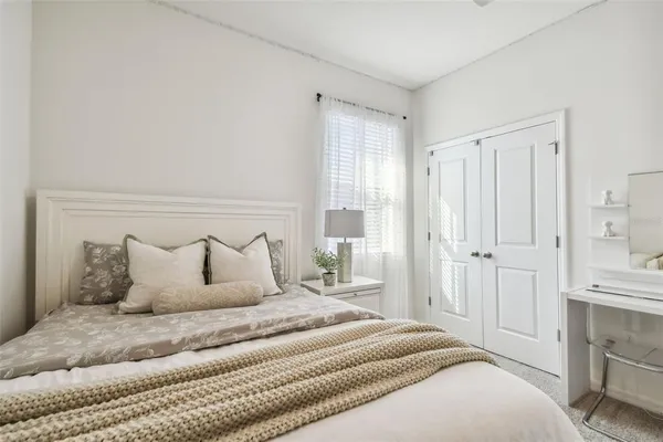 a bedroom with a bed and a refrigerator
