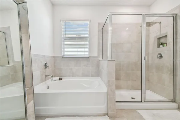 a white bath tub sitting next to a shower