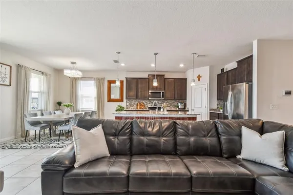 a living room with furniture kitchen view and a large window