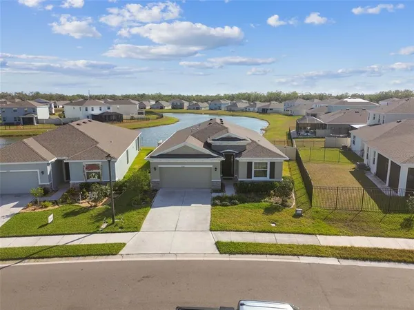 an aerial view of a house with a garden and lake view