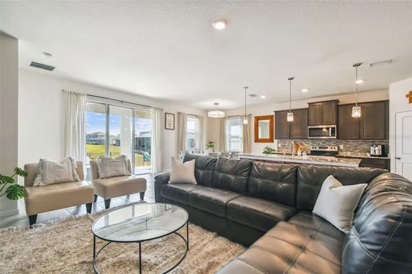 a living room with furniture kitchen and a large window