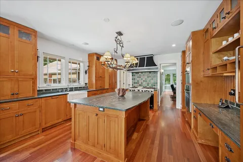 a kitchen with stainless steel appliances granite countertop a kitchen island a stove and a sink