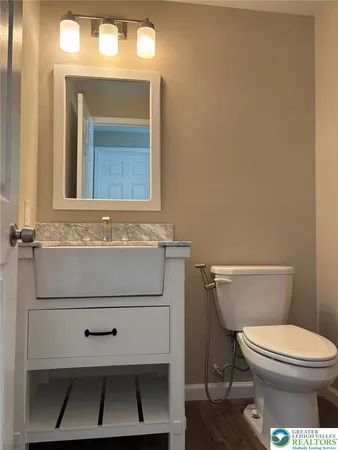 a room with stainless steel appliances granite countertop a sink a microwave cabinets and wooden floor