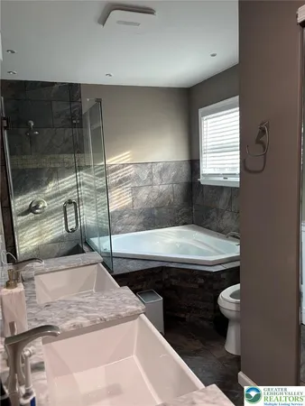 a bathroom with a granite countertop sink a toilet and bathtub