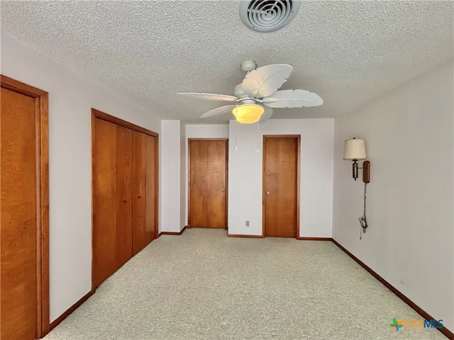 a view of an empty room with a chandelier fan