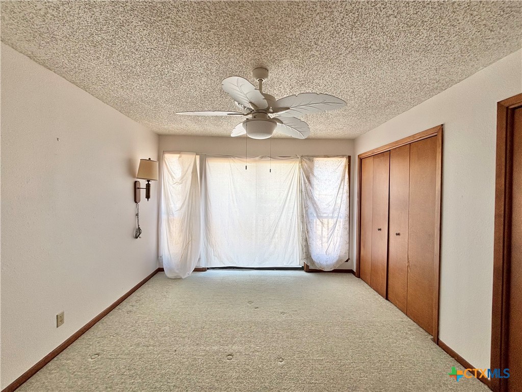 440 15th Street Port O'Connor, TX 77982 - Photo 20 of 40 an empty room with windows and fan
