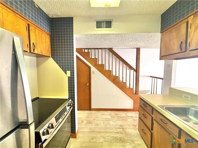 a view of a livingroom with furniture and a refrigerator