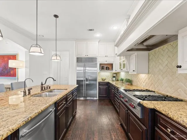 a kitchen with stainless steel appliances granite countertop a sink stove and refrigerator