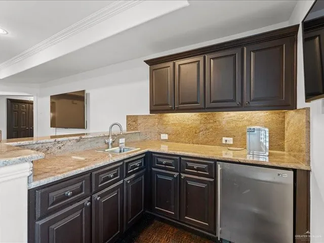 a kitchen with granite countertop stainless steel appliances a sink stove and cabinets