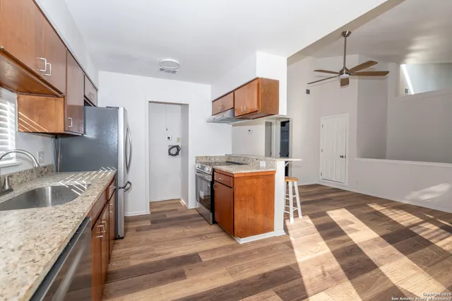 a kitchen with granite countertop a sink a counter top space and cabinets