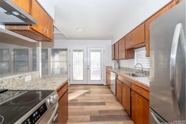 a large kitchen with stainless steel appliances granite countertop a stove and a sink