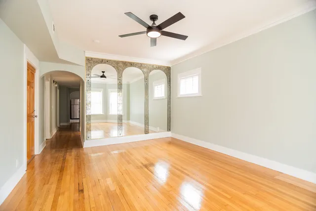 a view of a room with wooden floor and a ceiling fan