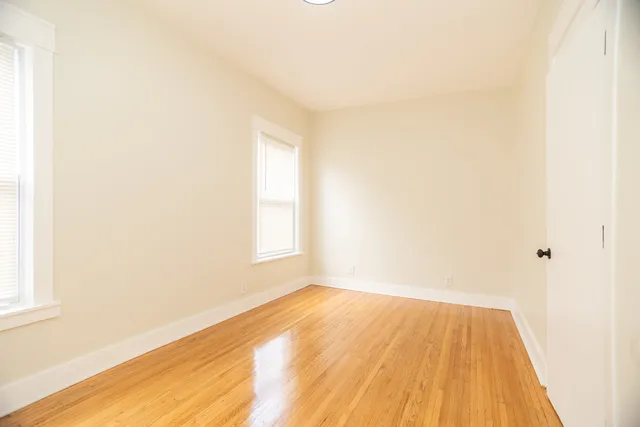 a view of a room with wooden floor and a window