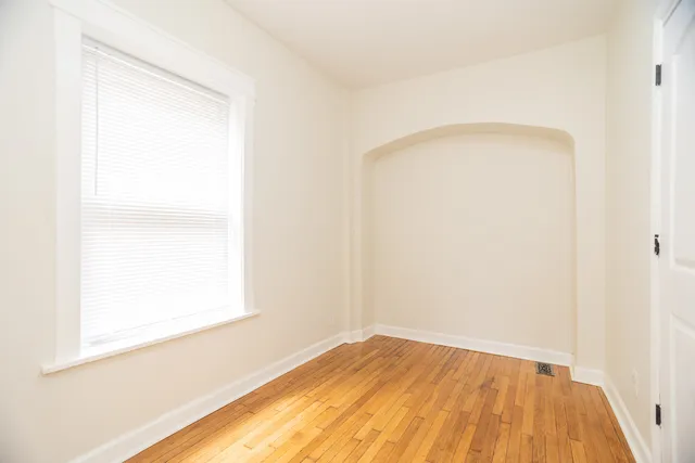 a view of empty room with wooden floor