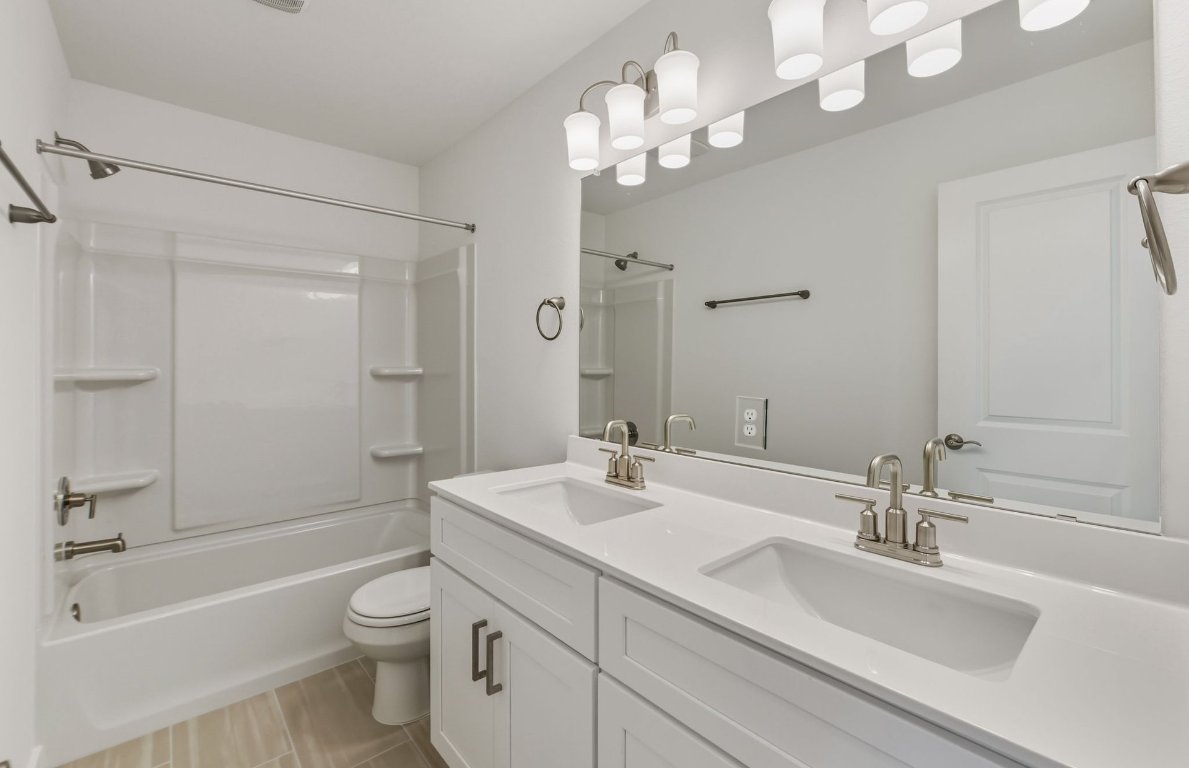 480 Tailwind Drive Kyle, TX 78640 - Photo 11 of 17 a bathroom with a sink a toilet and a large mirror