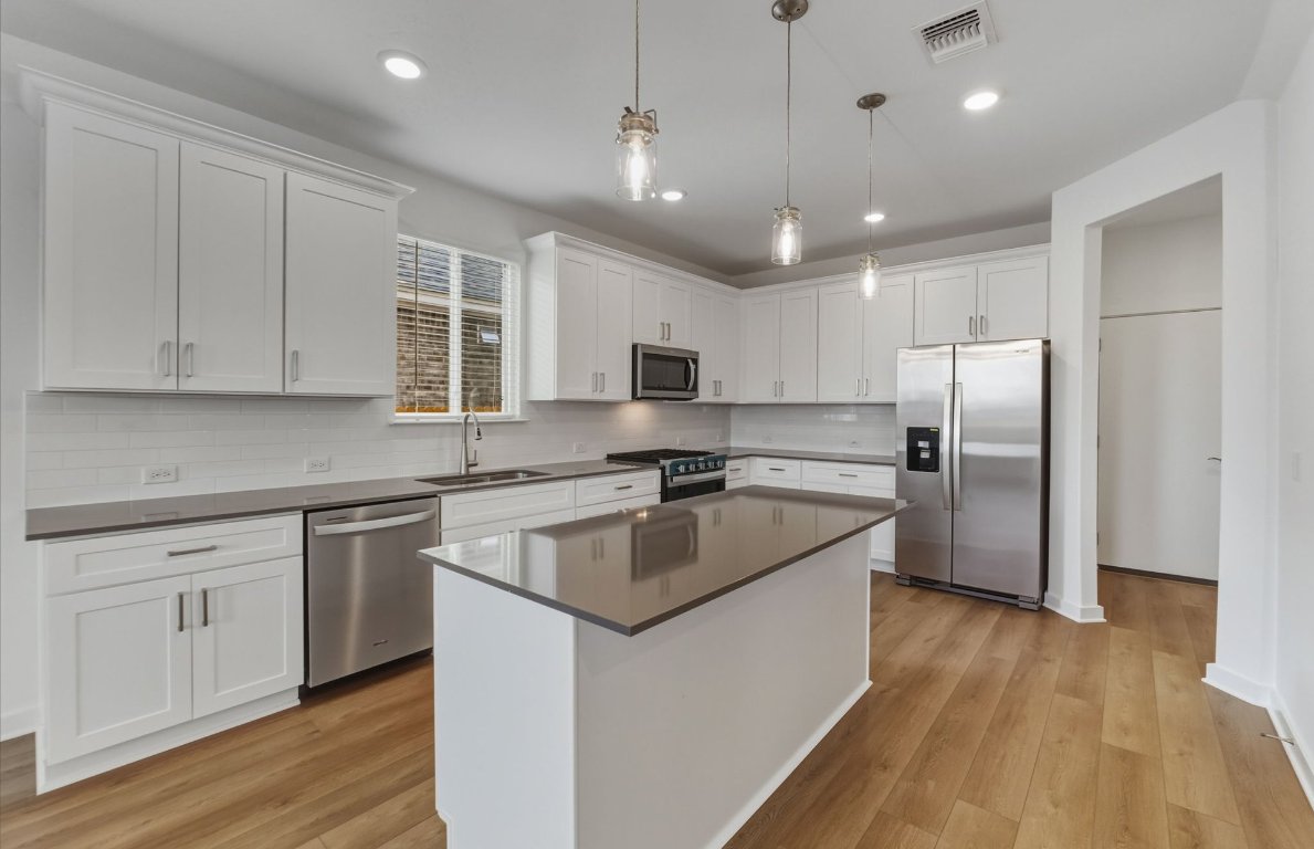 480 Tailwind Drive Kyle, TX 78640 - Photo 4 of 17 a kitchen with kitchen island granite countertop a sink stainless steel appliances and cabinets
