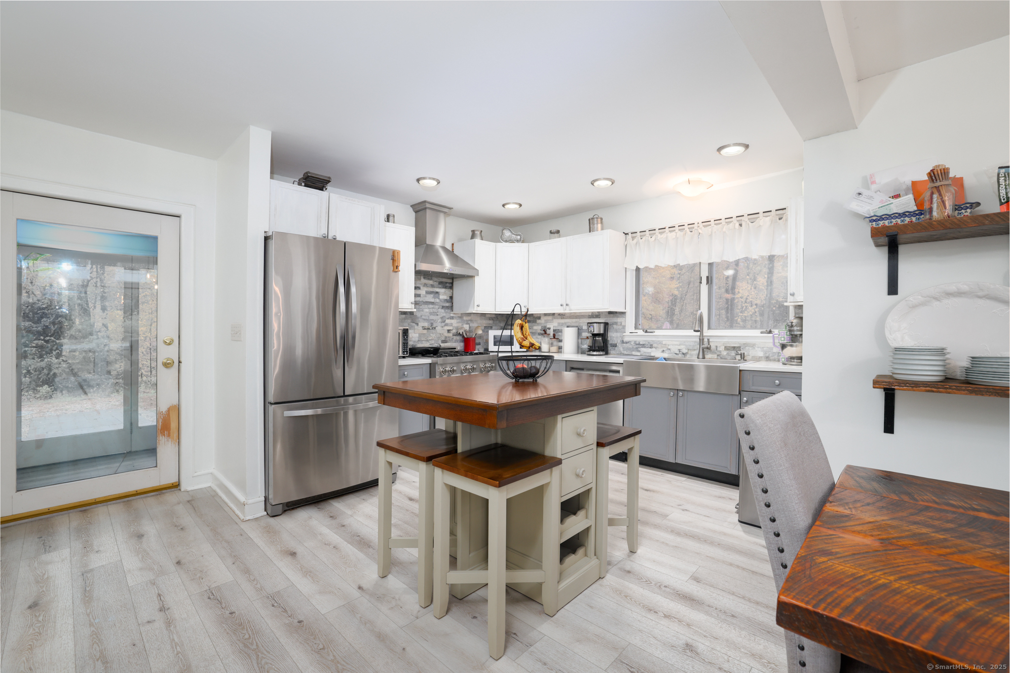 266 Old Forge Road Riverton, CT 06065 - Photo 14 of 40 a kitchen with stainless steel appliances kitchen island granite countertop a refrigerator a stove a sink and a dining table with wooden floor