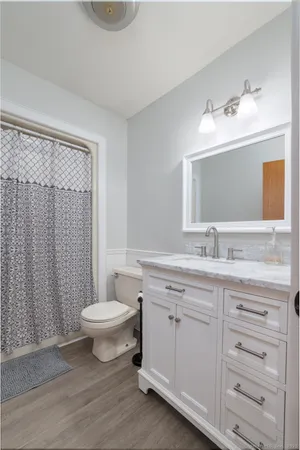 a bathroom with a granite countertop sink toilet a large mirror and shower