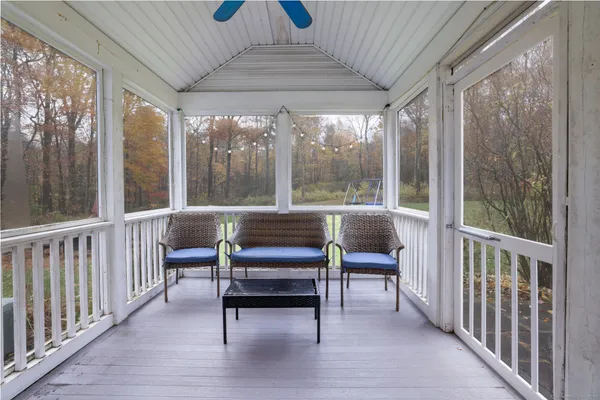 a view of a porch with chairs and backyard