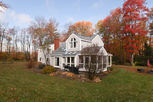 a view of a house with a big yard and large trees