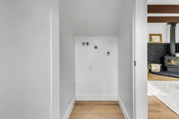 a view of a hallway with a livingroom and a bathroom with sink