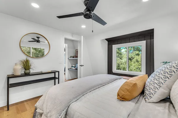 a bedroom with a bed mirror and window