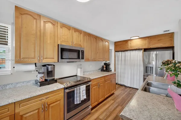 a kitchen with granite countertop a sink appliances and cabinets