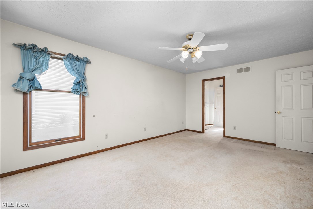 722 Jaycox Road Avon Lake, OH 44012 - Photo 23 of 48 Spacious room featuring neutral carpeting, a multi-pane window with wood-finish trim, and a ceiling fan with integrated lighting