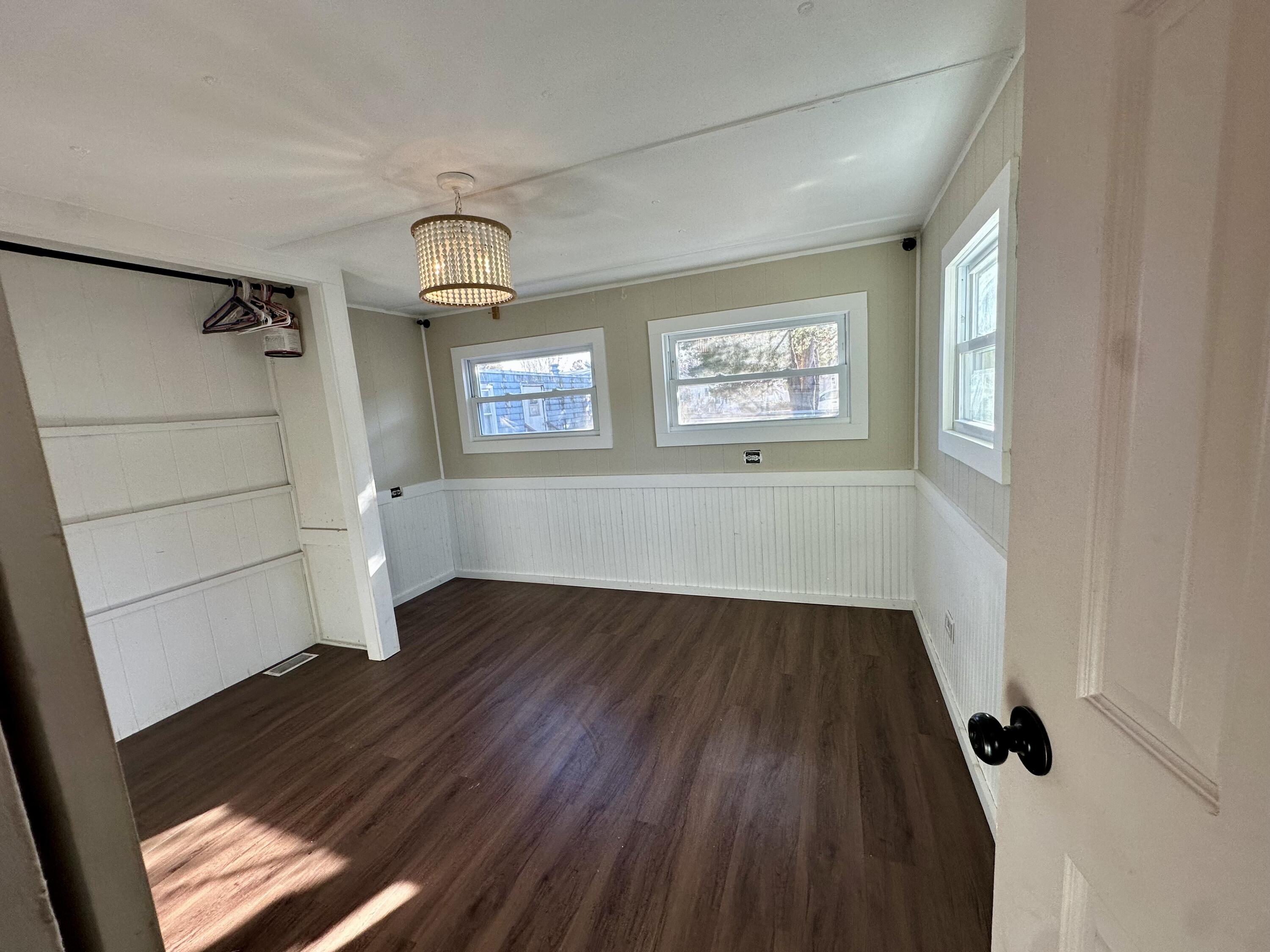 5 3rd Avenue Bourne, MA 02559 - Photo 8 of 18 an empty room with wooden floor cabinet and windows