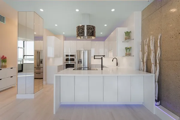 a large kitchen with stainless steel appliances kitchen island a large counter top and a sink