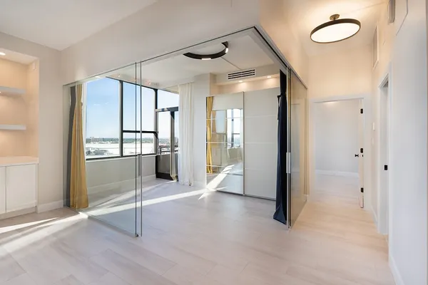an empty room with wooden floor and windows