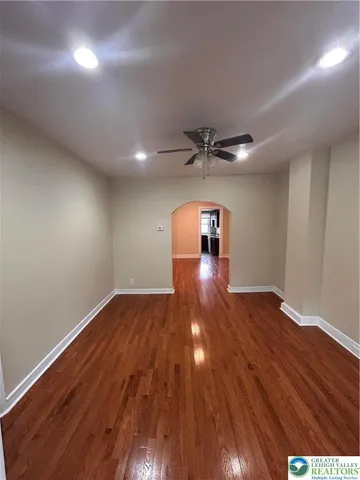 a view of empty room with wooden floor