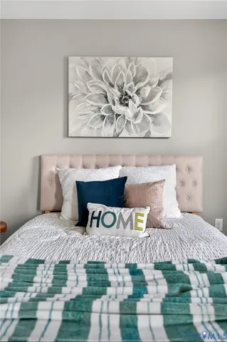 a bedroom with a bed and painting on the wall