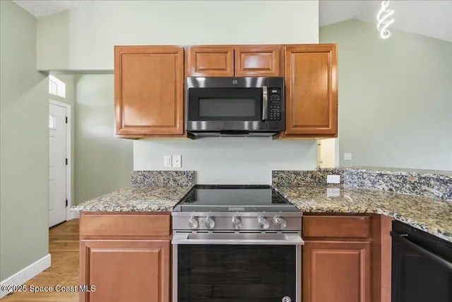 a kitchen with stainless steel appliances granite countertop a stove and a microwave