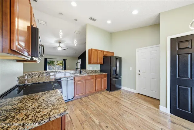a kitchen with stainless steel appliances granite countertop a sink stove and refrigerator